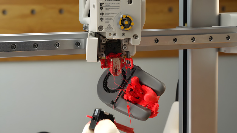 A 3D printer failing, covered in red sticky substance.