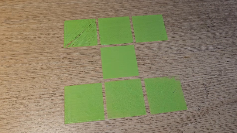 Multiple printed first layers with various defects on a table.
