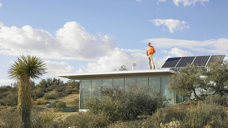 Person standing on a roof near solar panels