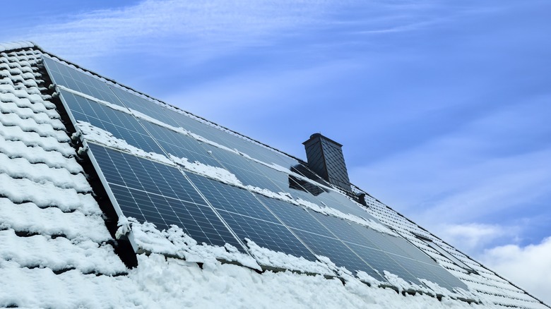 Snow-covered solar panels on a roof