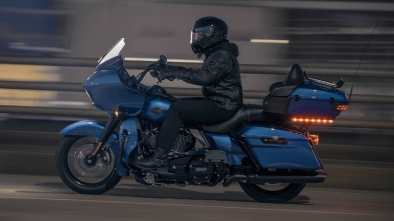 A Harley Davidson Road Glide Limited 2024 Model being ridden by a rider in full accessories, right to left