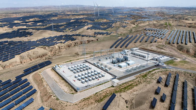 An aerial view of a photovoltaic solar farm built on dry land with stripped and disturbed ground.