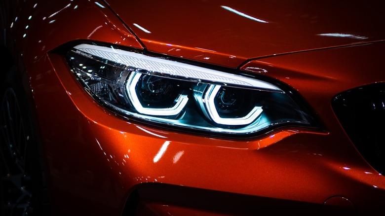 A red vehicle headlight on.