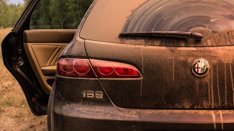 A very dirty car with its door open.