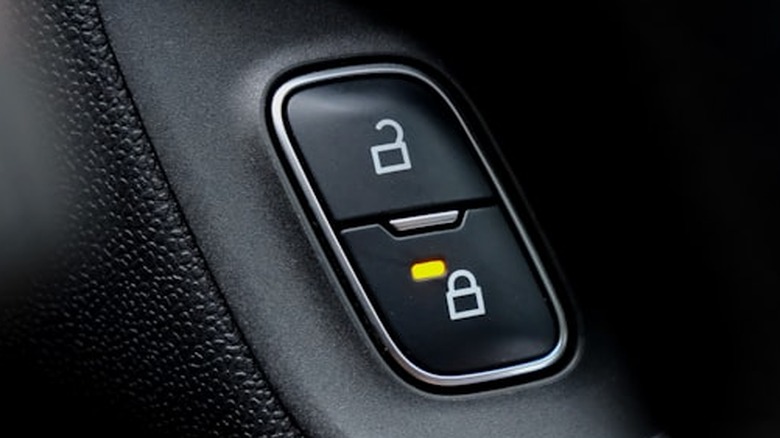 A black car lock button that is on.