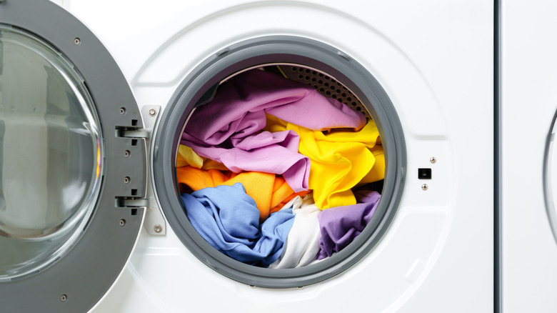 Open washing machine filled with clothes