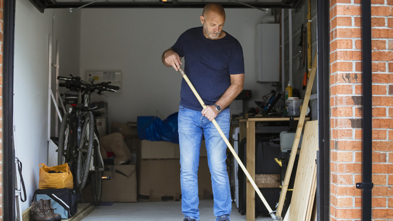 Man sweeping out garage