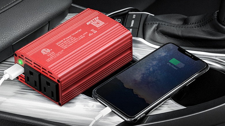 A BESTEK 300W Power Inverter charging a smartphone.