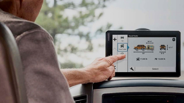 An elderly man making use of the Garmin RV 795 GPS Navigator's touchscreen.