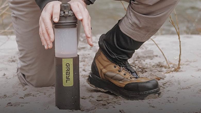 A man pushing down the Grayl GeoPress Purifier Bottle's inner cartridge.
