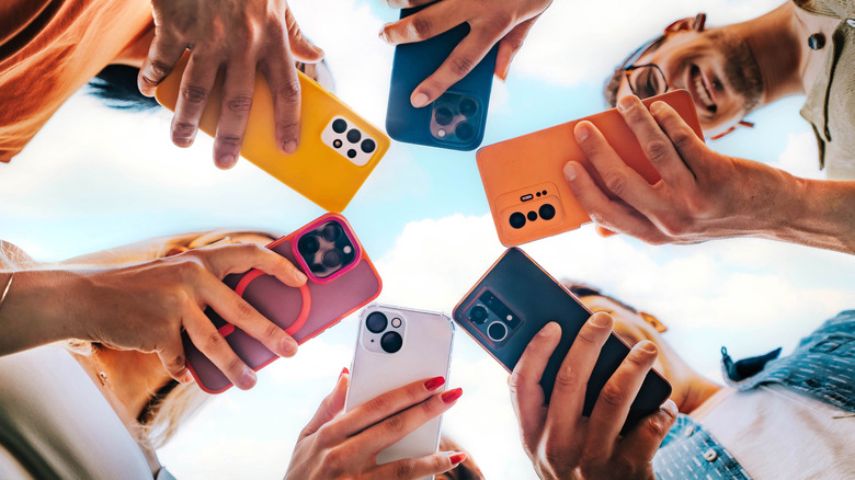 Six people with smartphones in hand form a circle, viewed from below