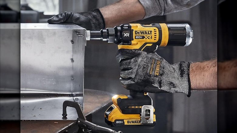 Using a riveting tool on a steel box