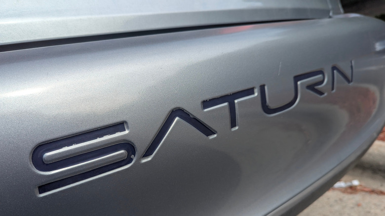 Closeup of the bumper of a Saturn logo on a car