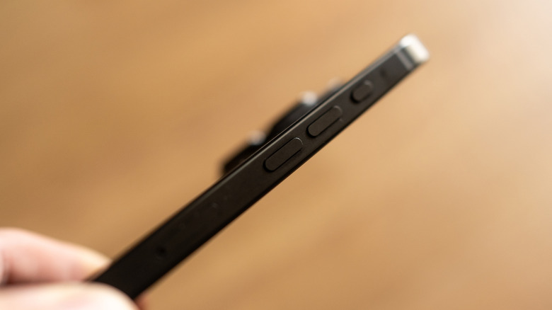 A person showing the side of an iPhone Action and volume buttons