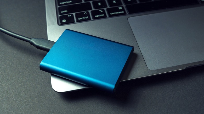 An external SSD next to a laptop