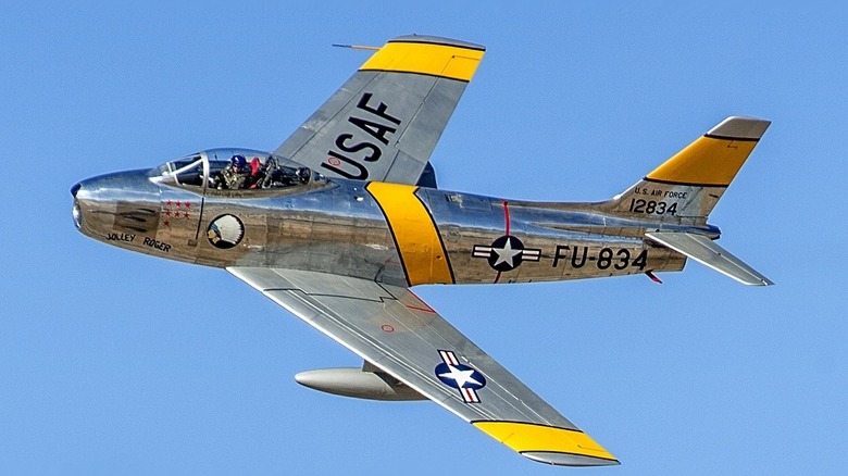 F-86 Sabre banking to the left in a clear blue sky