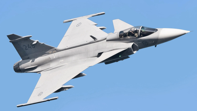 Saab Gripen fighter jet seen from the left in a blue sky