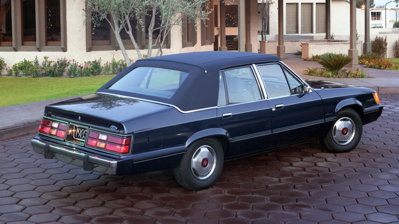 Dark blue 1985 Ford LTD Brougham seen from behind right parked in a driveway
