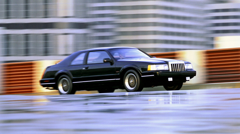 Black 1992 Lincoln Mark VII coupe seen from right front on a city street
