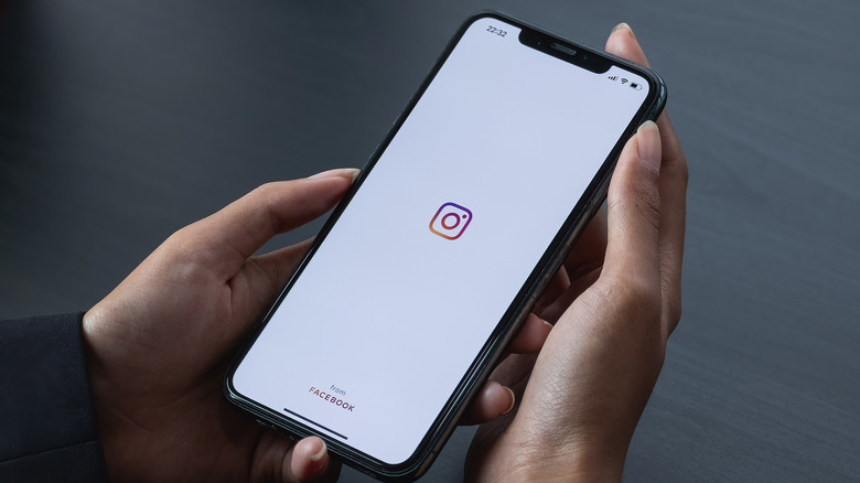 Person holding smartphone showing Instagram logo