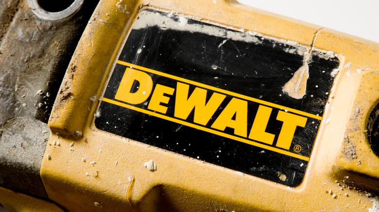 A DeWalt logo on the side of a tool, moderately dirty.