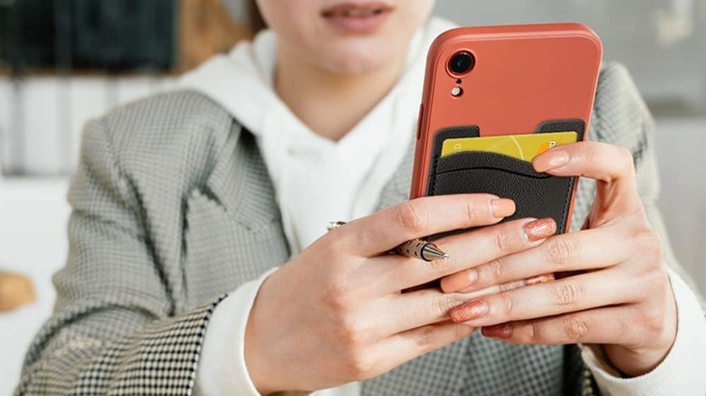 woman holding phone with wallet on back