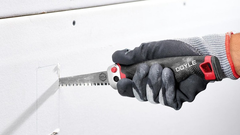 Person using a jab saw to cut drywall