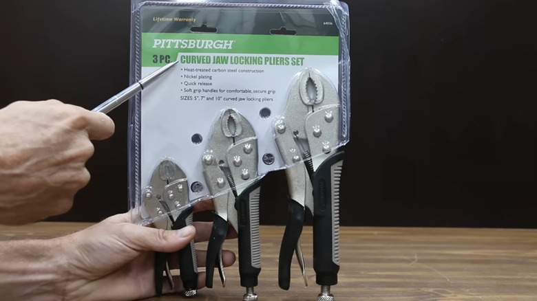 person pointing at plastic package with locking pliers inside