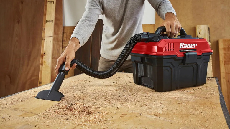 DIYer cleaning sawdust with a Bauer wet/dry vac.