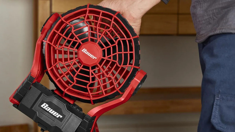 DIYer holding a Bauer dual-power fan.