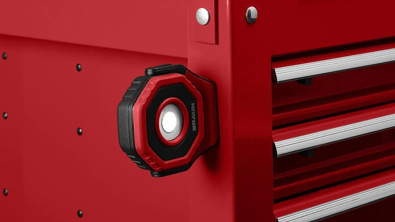 A red Braun LED floodlight attached to a red tool box.
