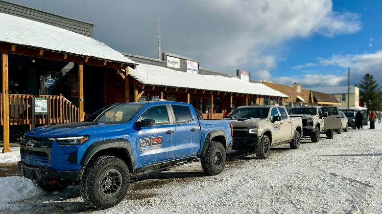 A Chevy Silverado parked in front of a bunch of trucks in the snow