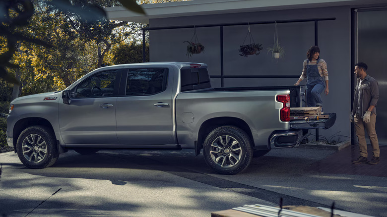 Two people using the multi-flex tailgate of their Chevy Silverado