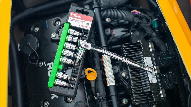 Hyper Tough 9-Piece ⅜-inch Drive Standard Star Socket Bit Set and ratchet on an engine