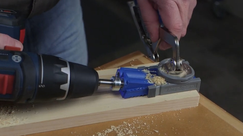 Drilling into lumber with a pocket hole jig as guide