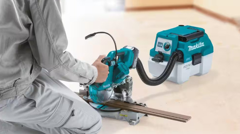 person using saw with vacuum attached