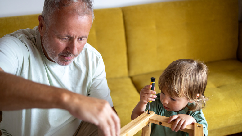 kid and adult assembling furniture