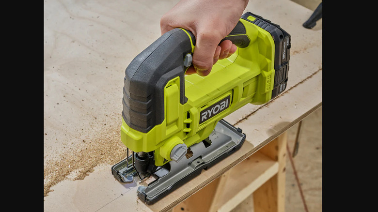 person cutting wood with a jig saw