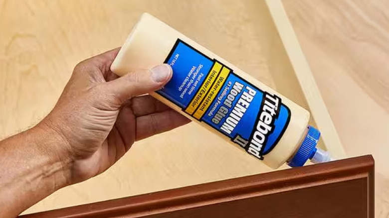 person applying glue to a drawer