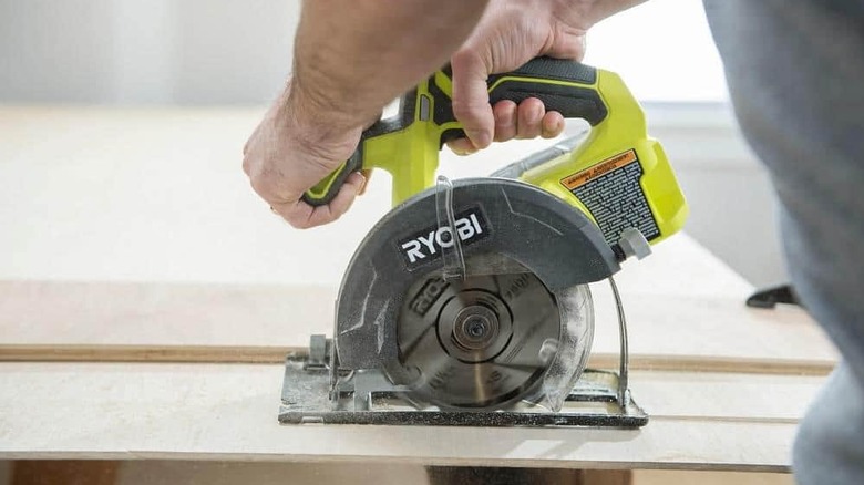 A circular saw cutting through wood.