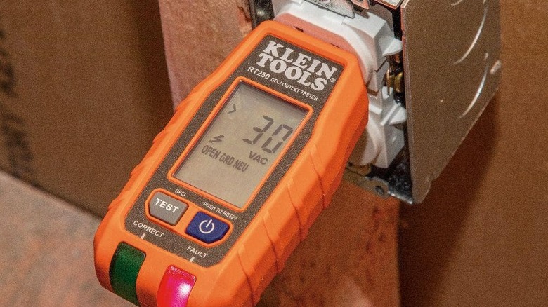 An outlet tester being used on an outlet.