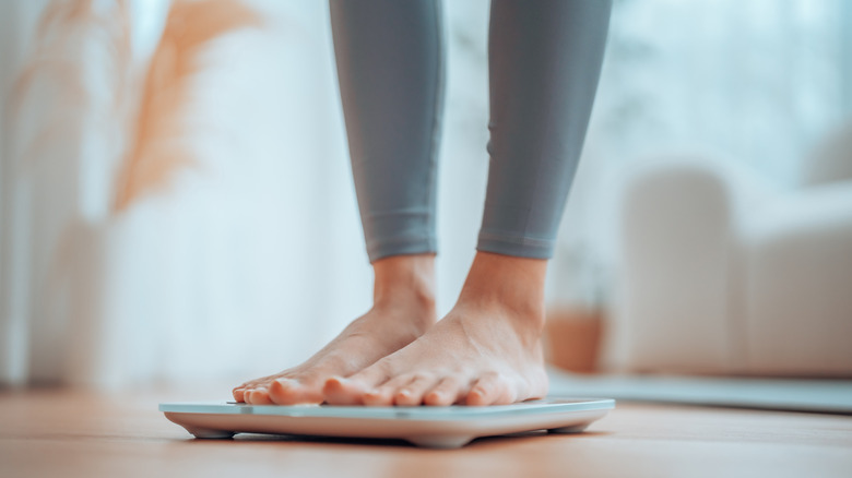 Woman's feet standing on a scale