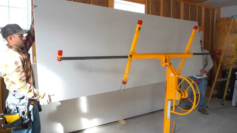 Josh from The Excellent Laborer using a lift to install drywall