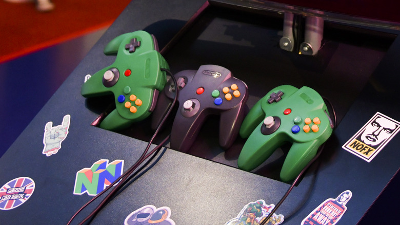 three Nintendo 64 controllers