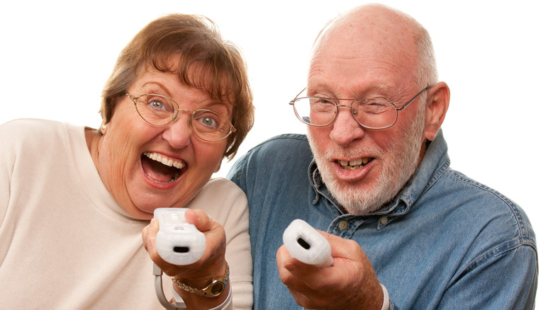 elderly couple using Wii remotes