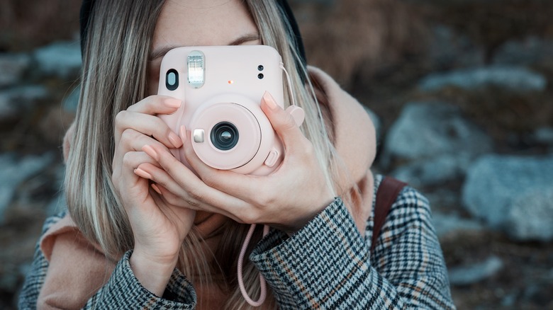 Woman holding pink camera