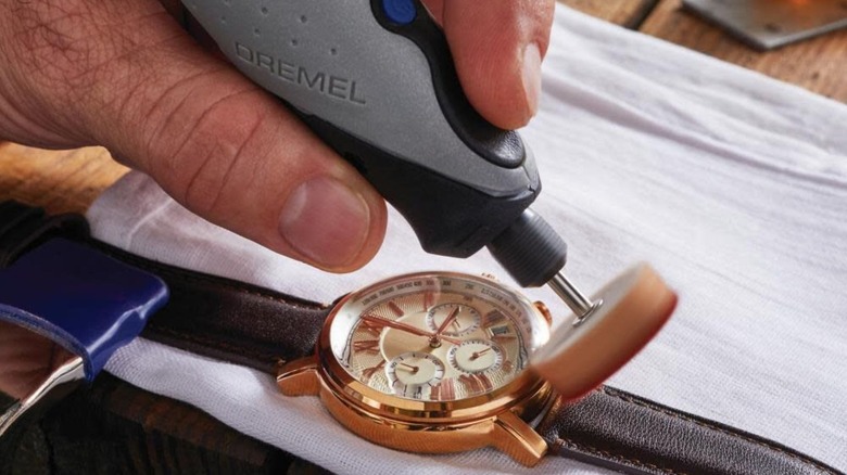 man using Dremel Stylo+ Craft Tool to fix watch