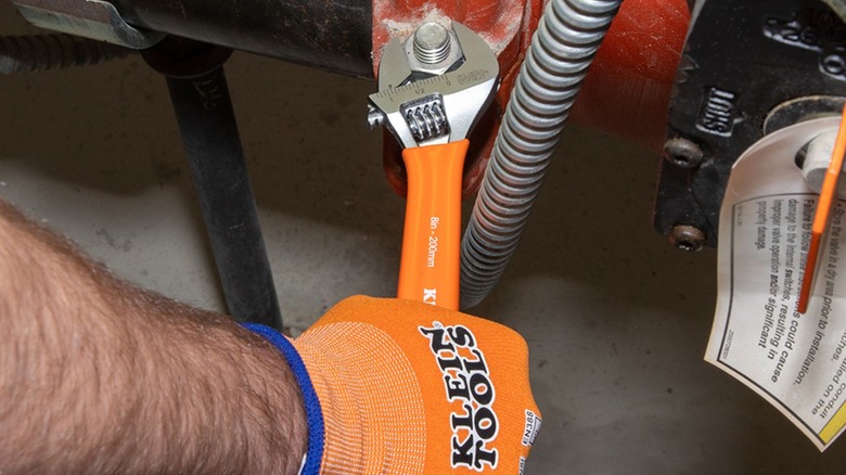 man using Klein Tools adjustable wrench