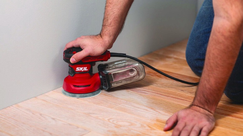 man using Skil Random Orbital Sander