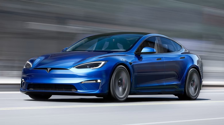 A blue Tesla Model S speeding down a road.